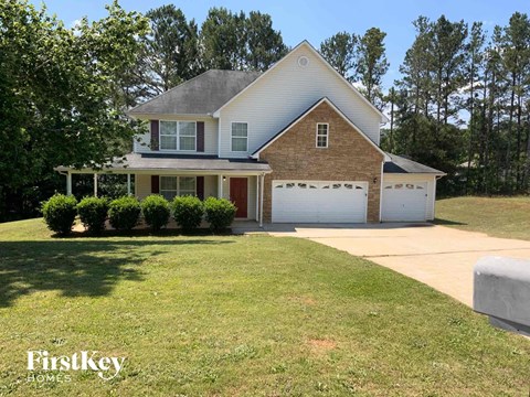 a brick house with a lawn and a white garage door