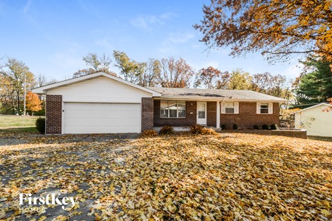 a house with a yard covered in leaves on the ground