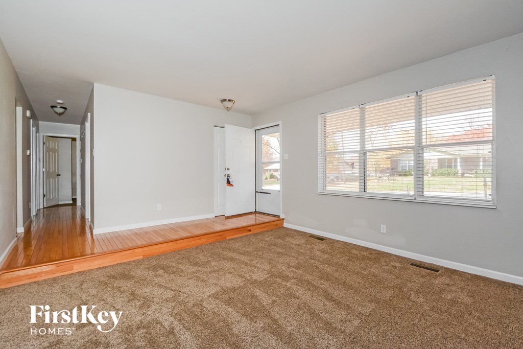 a living room with a rug and a large window