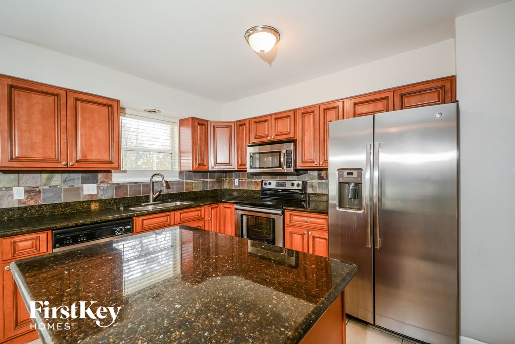 full view of the kitchen with granite countertops and stainless steel appliances