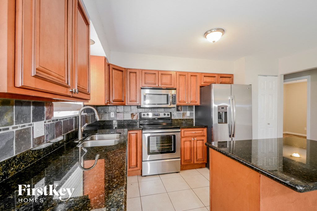a kitchen with granite counter tops and wooden cabinets