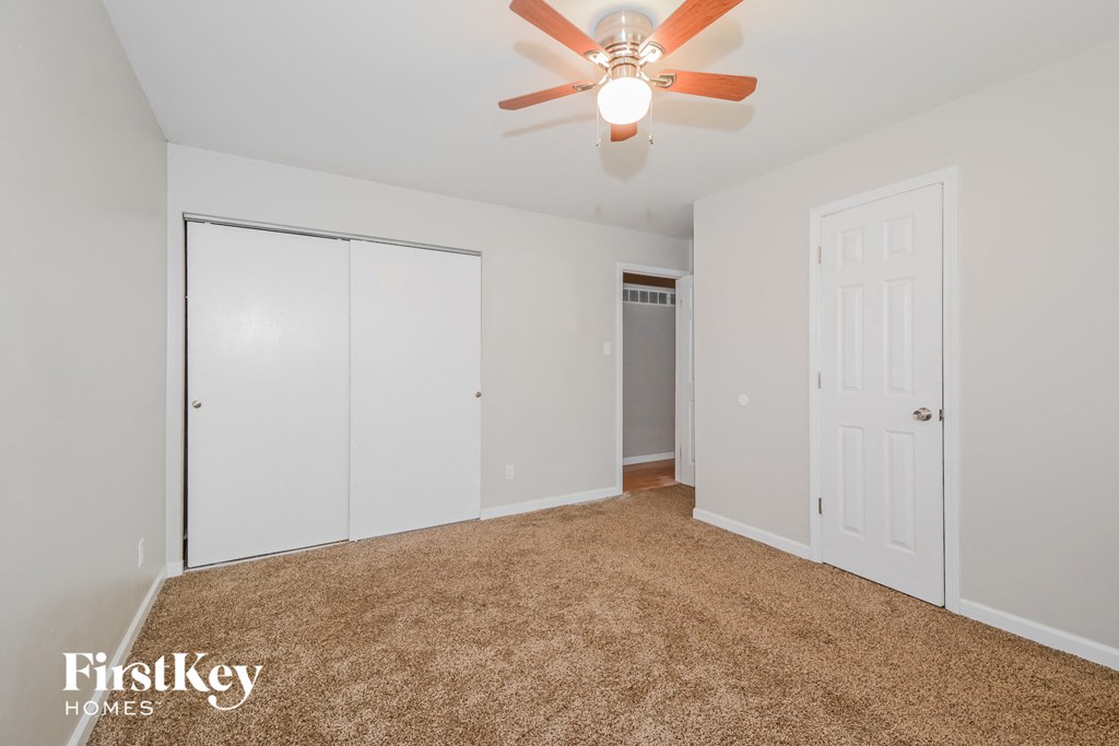 a bedroom with a ceiling fan and a closet