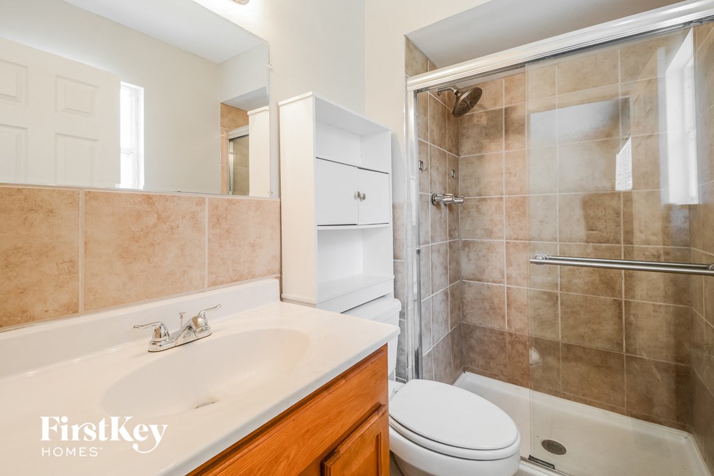 a bathroom with a sink toilet and shower