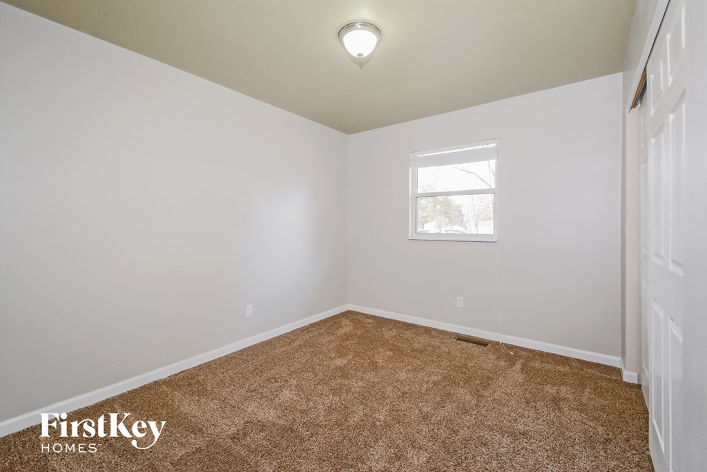 a bedroom with a carpeted floor and a window