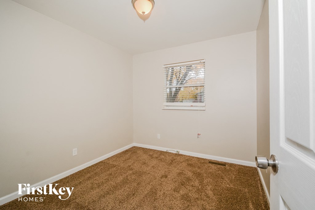 a bedroom with a carpeted floor and a window