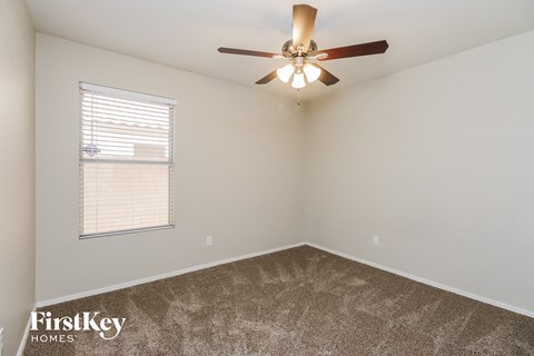 a bedroom with a ceiling fan and a window