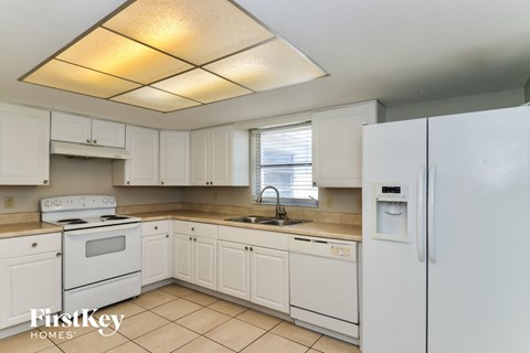 a white kitchen with white appliances and white cabinets