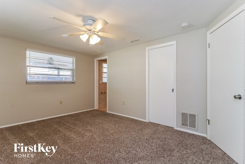 a bedroom with a carpeted floor and a ceiling fan
