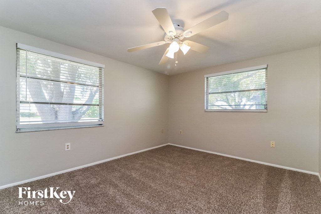 the master bedroom has carpeted floors and a ceiling fan