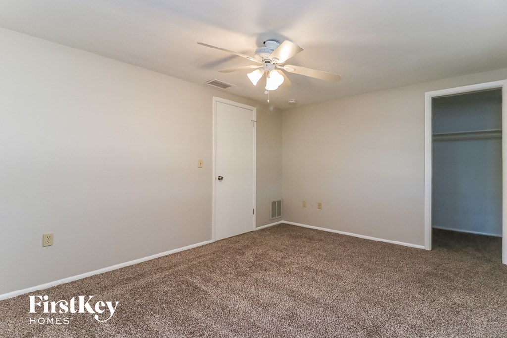 a room with a carpeted floor and a ceiling fan