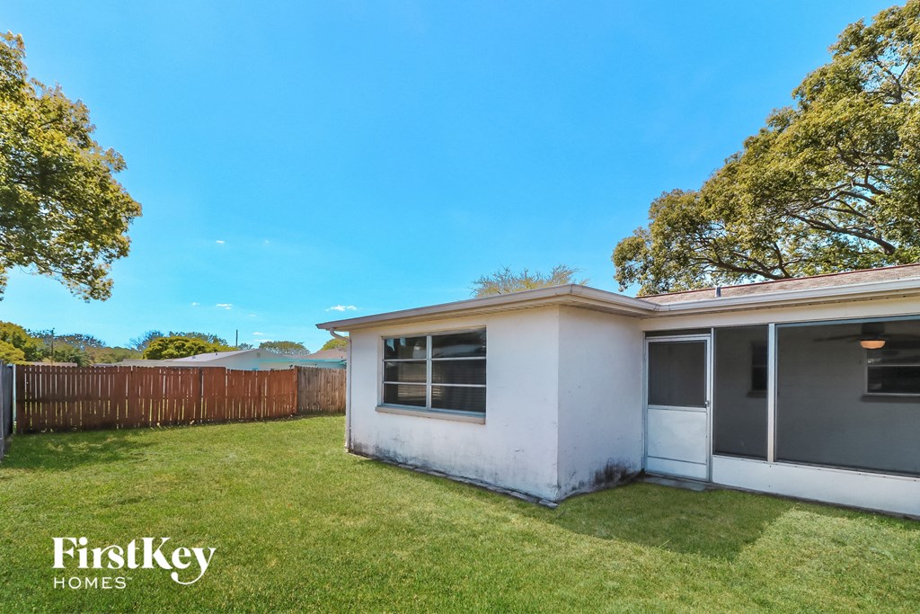 a small white house with a yard and a fence
