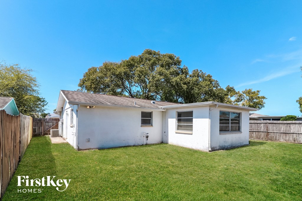 a small white house with a yard and a fence