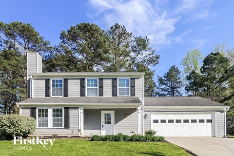 a white house with a white garage door and a lawn