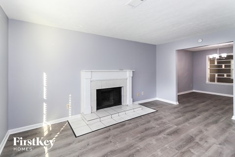 a living room with a fireplace and a wooden floor