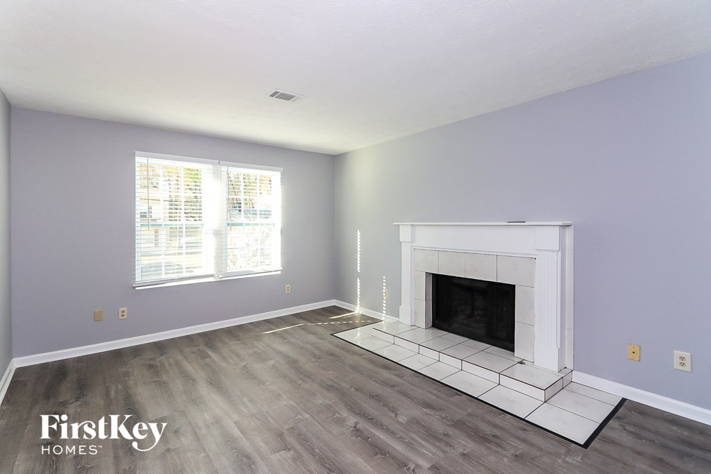 the living room has a fireplace and hardwood floors
