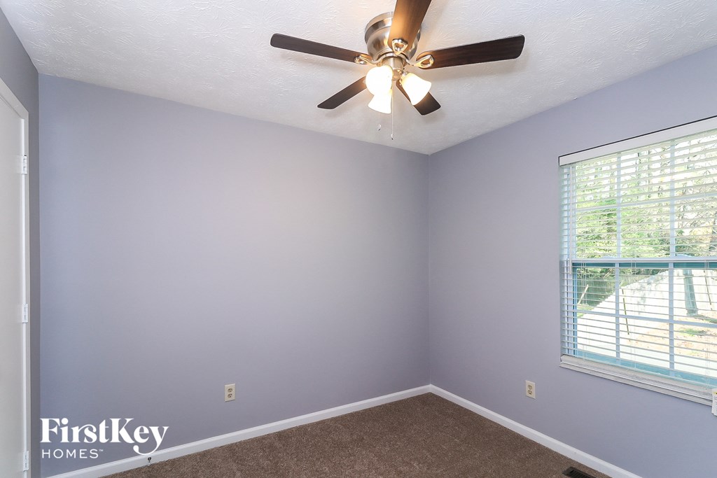 a bedroom with a ceiling fan and a window