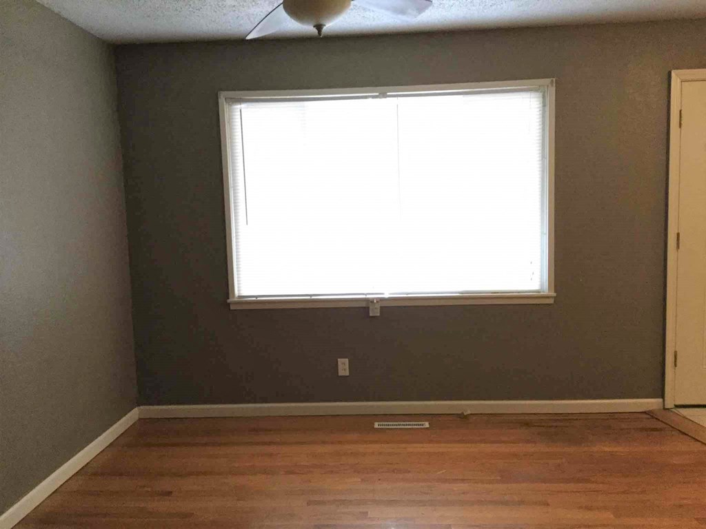 A room with a window and a ceiling fan.