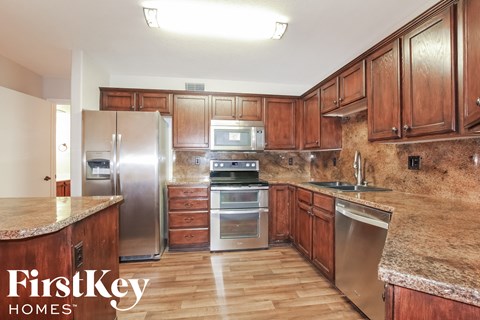 a kitchen with wooden cabinets and stainless steel appliances