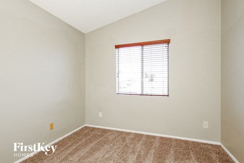 the living room of a home with a window and carpet