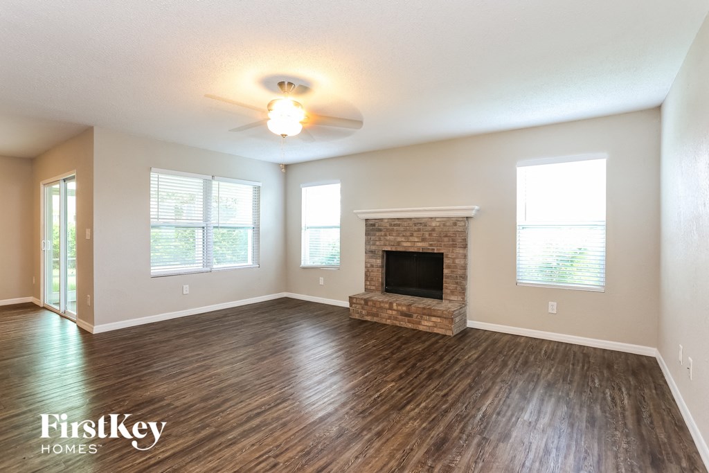 the living room with wood flooring and a fireplace