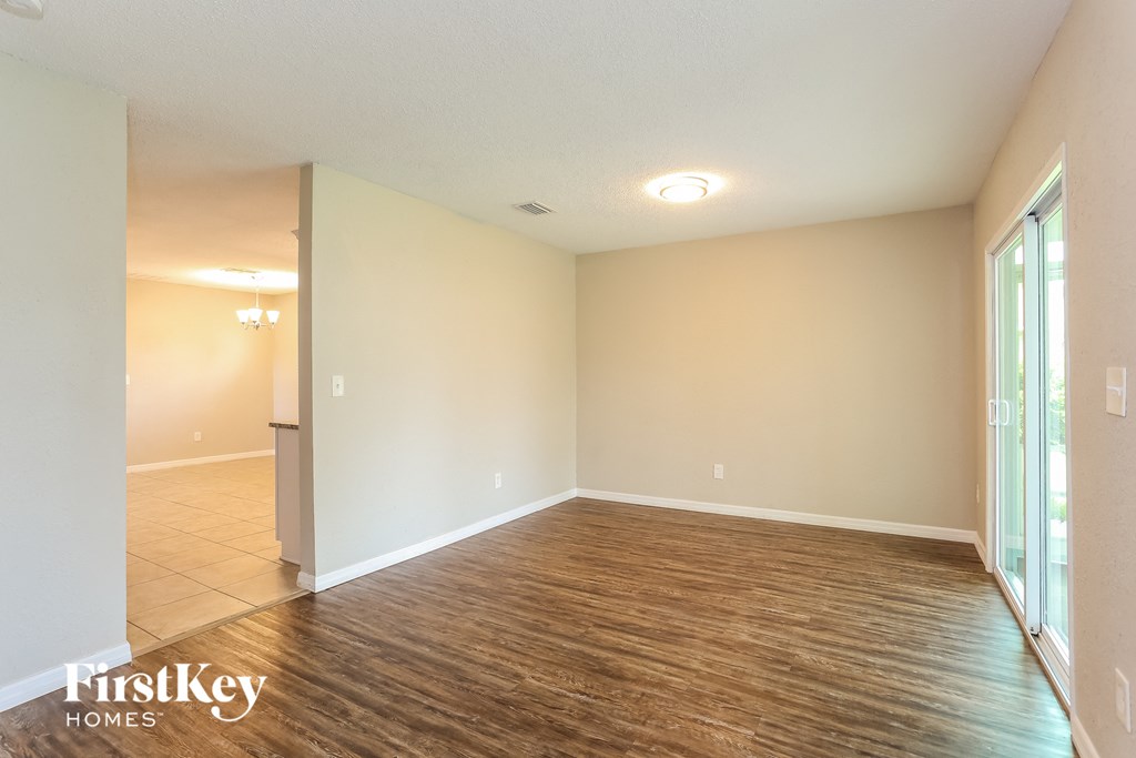 an empty living room with wood flooring and white walls
