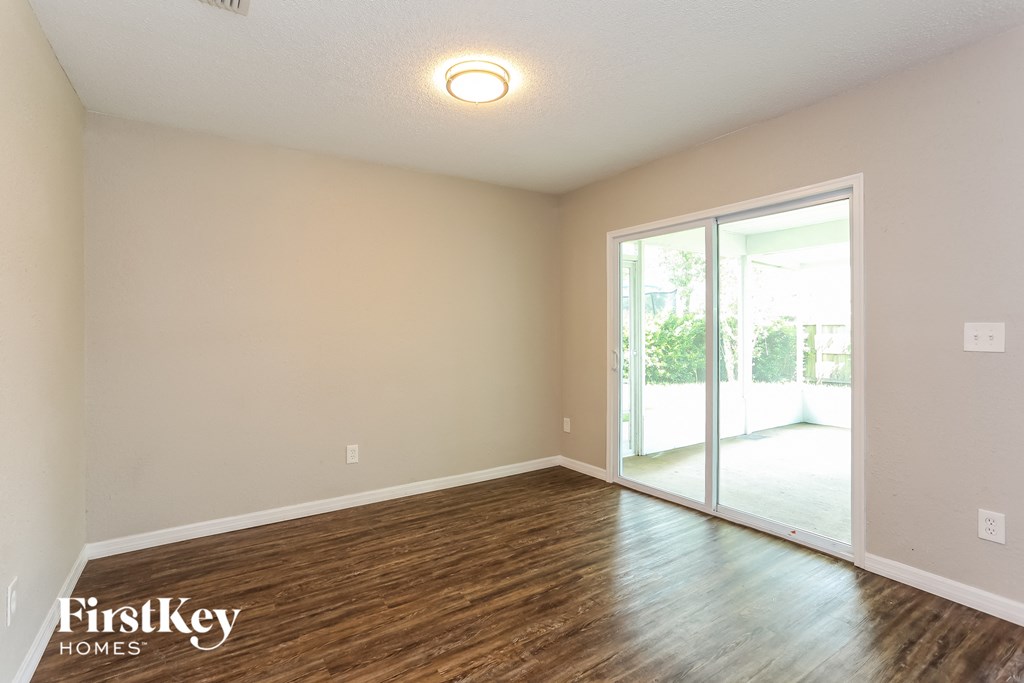 a living room with wood flooring and a sliding glass door