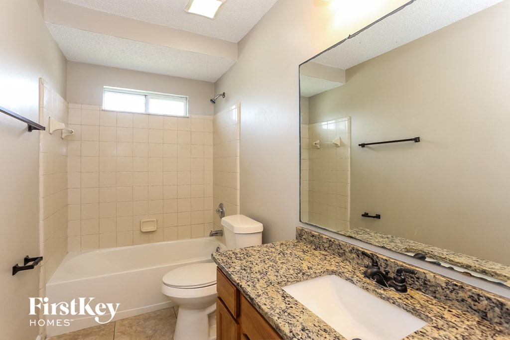 the master bathroom has a tub and a sink and a toilet