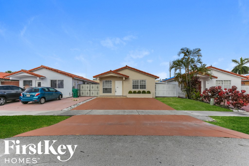 a home with a driveway and cars parked in front of it