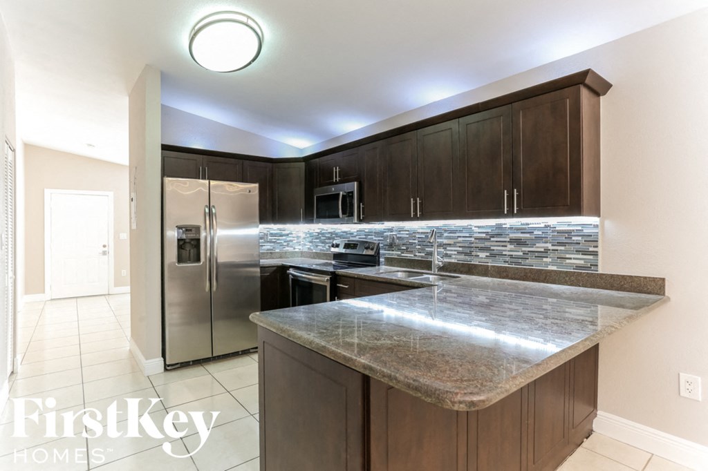 a modern kitchen with granite counter tops and stainless steel appliances