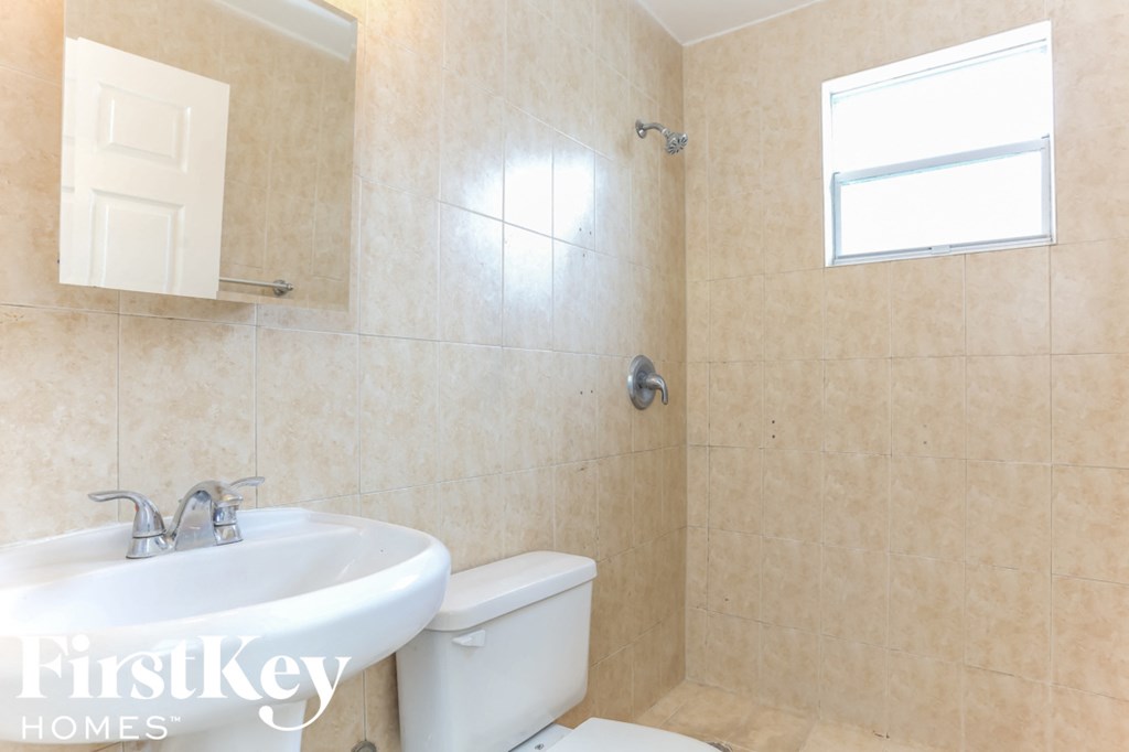 a bathroom with a sink and a toilet and a window