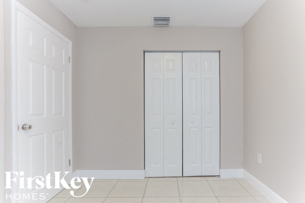 a room with two closet doors and a tiled floor