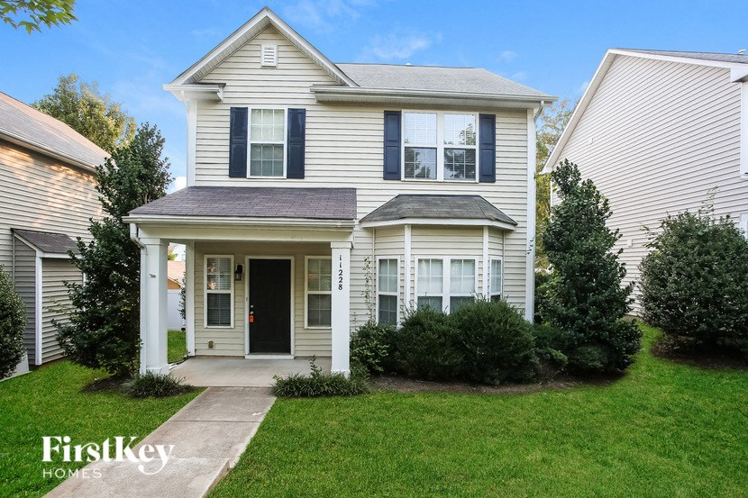 a white house with a sidewalk in front of it