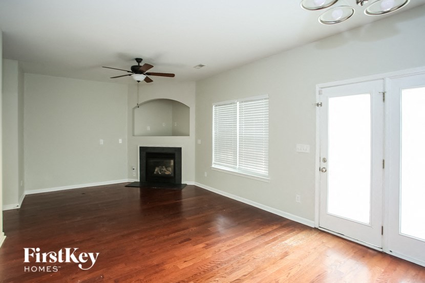 an empty living room with wood floors and a fireplace