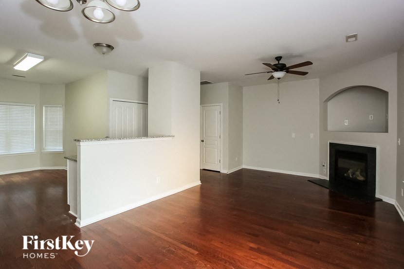 an empty living room with wood flooring and a fireplace