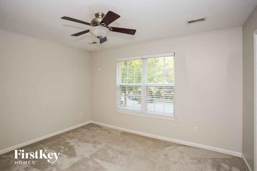 a bedroom with a ceiling fan and a window