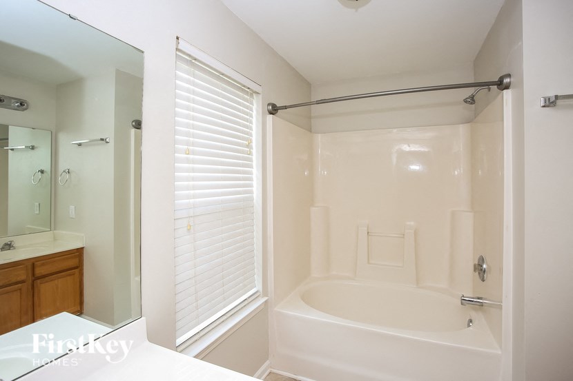 a bathroom with a tub and a shower and a sink