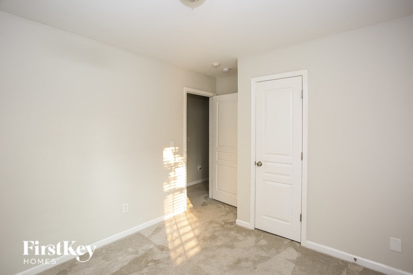 a bedroom with a closet and a door to a hallway