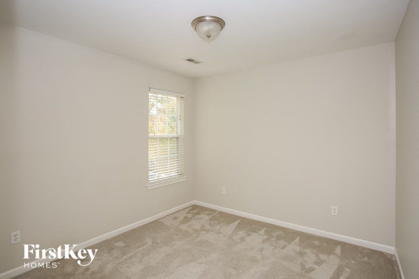 a bedroom with white walls and a window