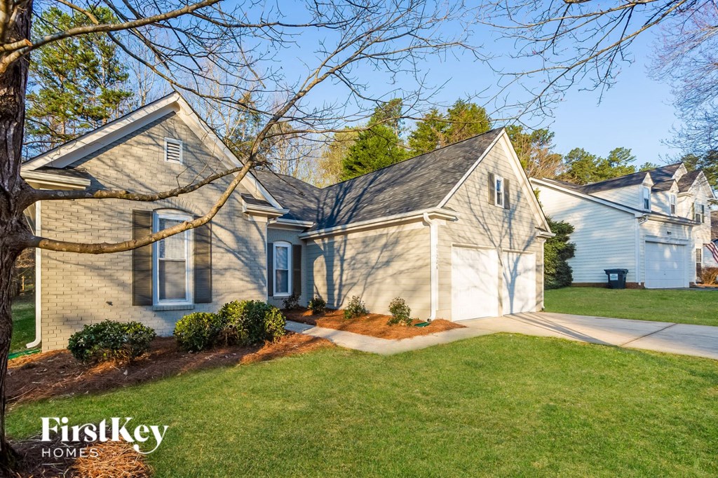 a blue and white house with a lawn and a driveway