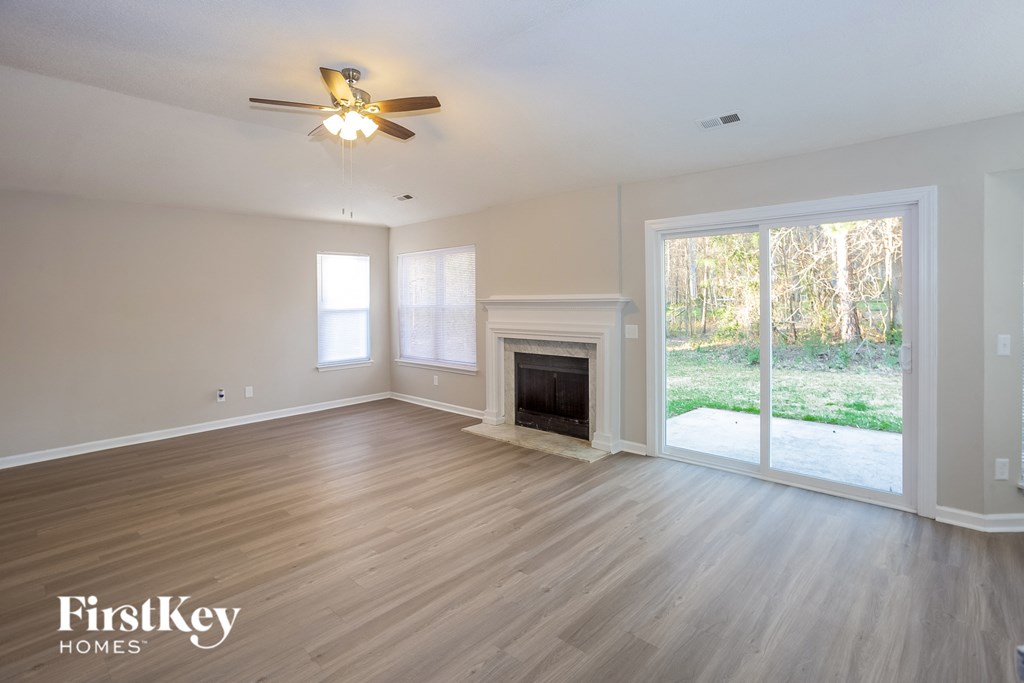 a living room with a fireplace and a ceiling fan