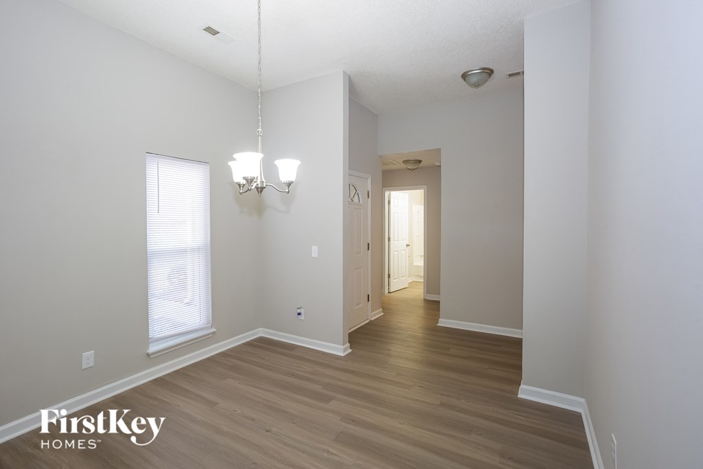 a renovated living room and hallway with white walls and wood floors