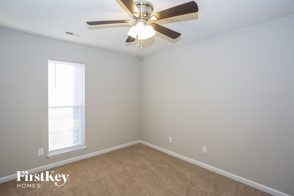 a bedroom with a ceiling fan and a window
