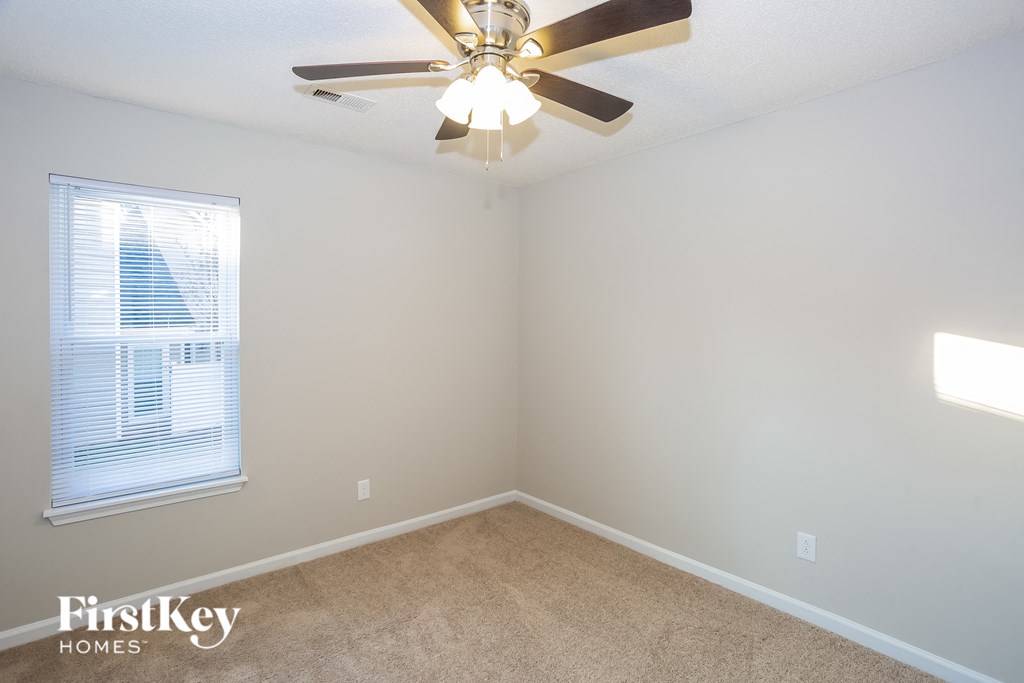 a bedroom with a ceiling fan and a window