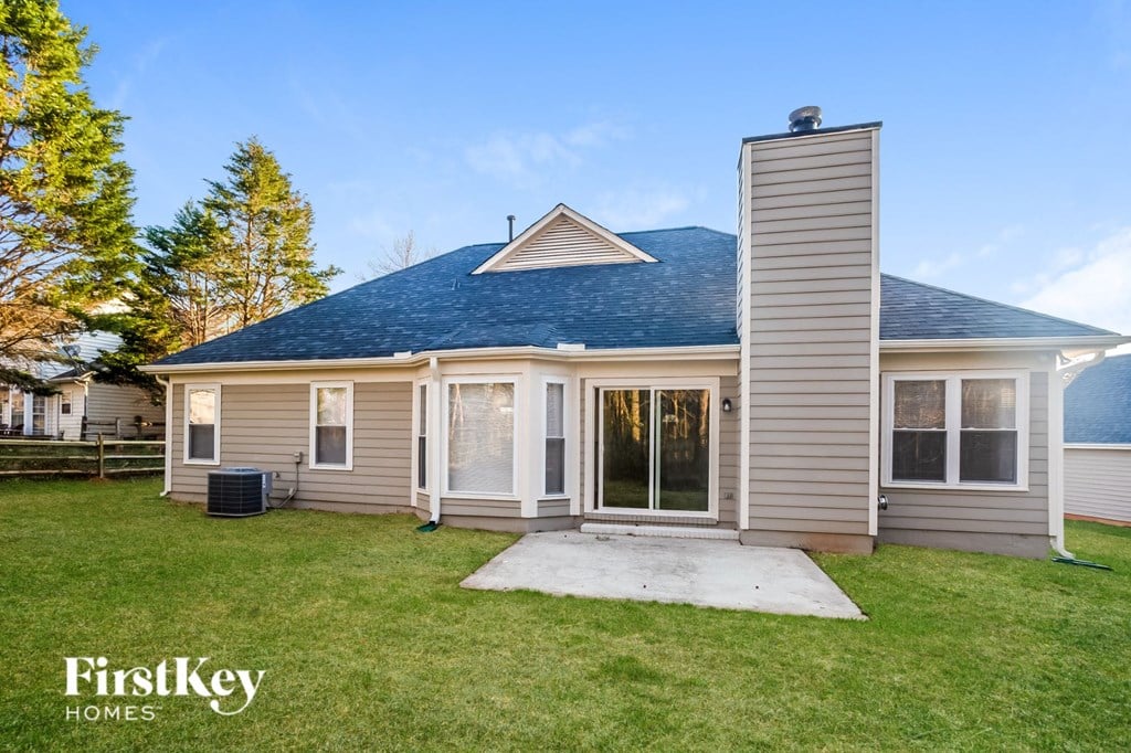 the front of a house with a yard and a concrete walkway