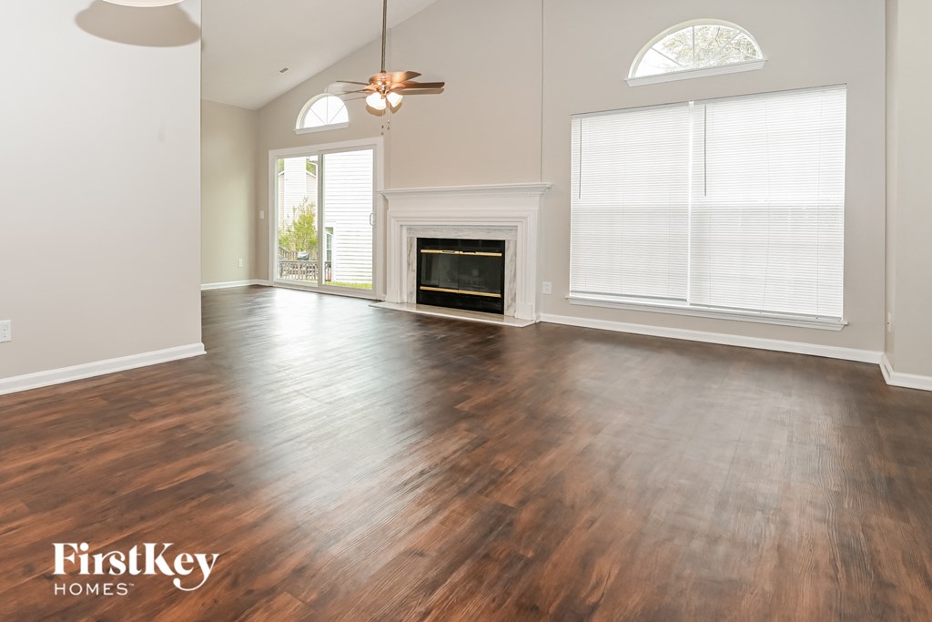 an empty living room with wood floors and a fireplace
