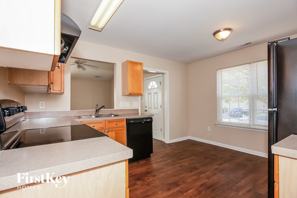 an empty kitchen with wood flooring and stainless steel appliances