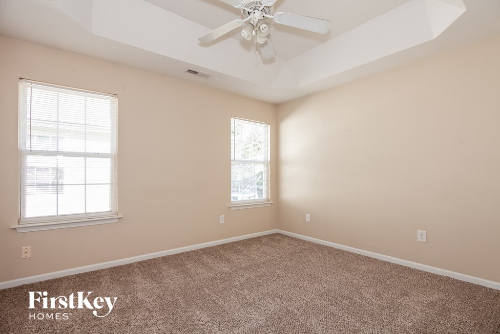 a living room with carpet and a ceiling fan