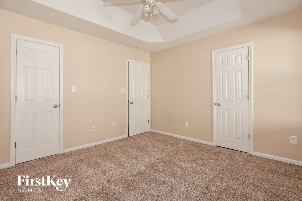 a empty room with two doors and a ceiling fan
