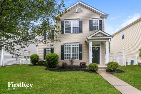 A house with a white picket fence in front of it.