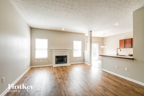 A spacious living room with a fireplace and wooden floors.